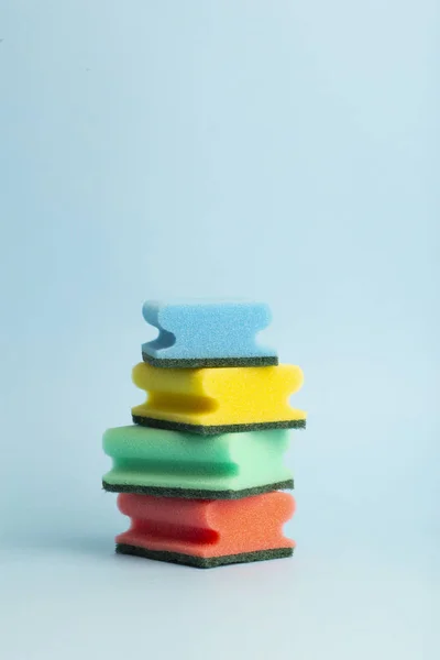 Esponjas coloridas para lavar pratos em um fundo azul. Mínimo — Fotografia de Stock