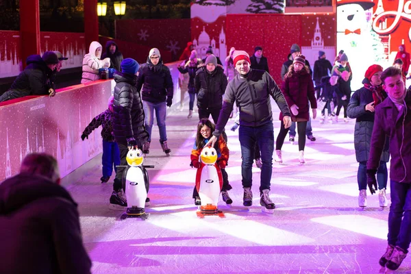 A young family with children skates at a city ice rink in the ev — стокове фото