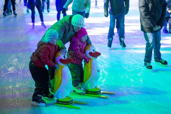 Une jeune famille avec des enfants patinent à une patinoire de la ville dans le ev — Photo