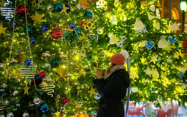 Menina fotografando uma árvore de Natal na cidade. Decoração de Natal — Fotografia de Stock