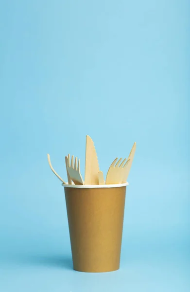 Tenedores de madera, cuchillos y cucharas para la comida en una taza de papel sobre un col — Foto de Stock