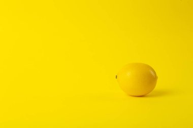 Summer and vitamins background. Lemon on a yellow background, mi clipart