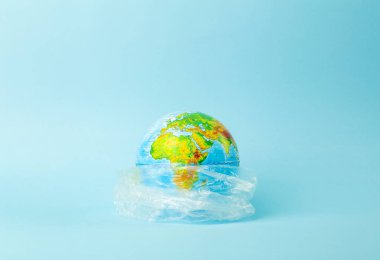 Plastik torba kirliliği. Dünya küresi plastik bir torba içinde