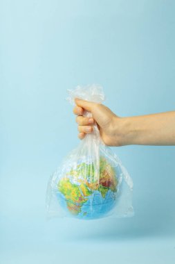 Plastik torba kirliliği. Dünya küresi plastik bir torba içinde