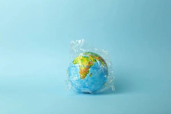 Plastic bag pollution concept. Earth globe in a plastic bag on a — 스톡 사진