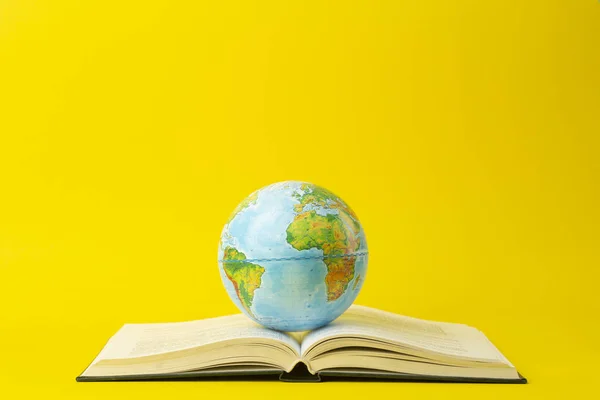 Istruzione e concetto di globalismo. Globo su un libro aperto su una tavola — Foto Stock