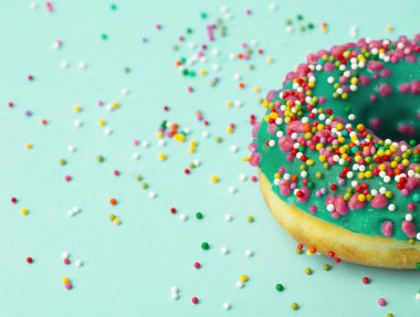 Yeşil arkaplanda farklı renkte donut (donut) 