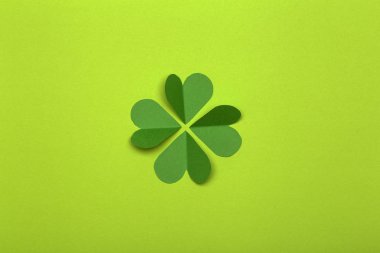 Aziz Patrick Günü (St. Paddy 's Day) arka plan kavramı. Yeşil arka plandaki kağıttan yeşil yonca. Yonca İrlanda ve Kelt kültürünün bir sembolüdür..