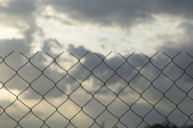 Kısıtlı alan kavramı. Yasak bölgeyi çevreleyen bir metal ağ çiti (karantina, hapishane, üretim alanı).