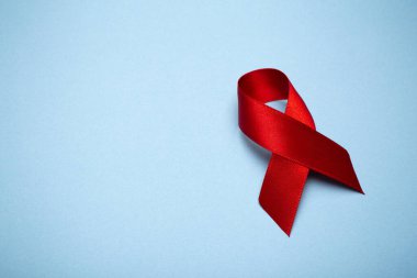Koyu gri arka planda kırmızı kurdele. Dünya AIDS Günü 'nün ya da kanserin ya da HIV Farkındalık Ayı' nın ve sağlık hizmetleri kavramının sembolü. Boşluğu kopyala.