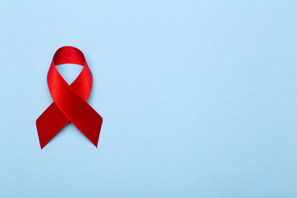 The red ribbon on a dark gray background. The symbol of The World AIDS Day or cancer or HIV Awareness Month and concept of healhcare. Copy space.