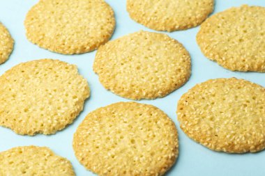 Mavi arka planda susamlı kurabiyeler. Pişirme ve tatlı arka planı. Ev mutfağı kavramı.