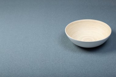 Arka planda halı var. Aynı renkte gri bir halı ve ahşap bir kase. İç tasarım ve üretim.