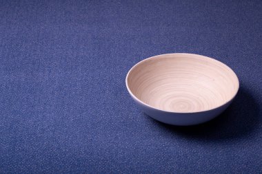 Arka planda halı var. Ahşap bir kaseyle aynı renkte mor bir halı. İç tasarım ve üretim.