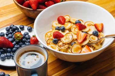 Kahvaltıda minik gözlemeler. Sabah kahvaltıda ev mutfağında çilekli krep ve yaban mersini pişirilir. Yiyecek Arkaplanı.