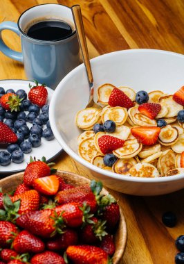 Kahvaltıda minik gözlemeler. Sabah kahvaltıda ev mutfağında çilekli krep ve yaban mersini pişirilir. Yiyecek Arkaplanı.