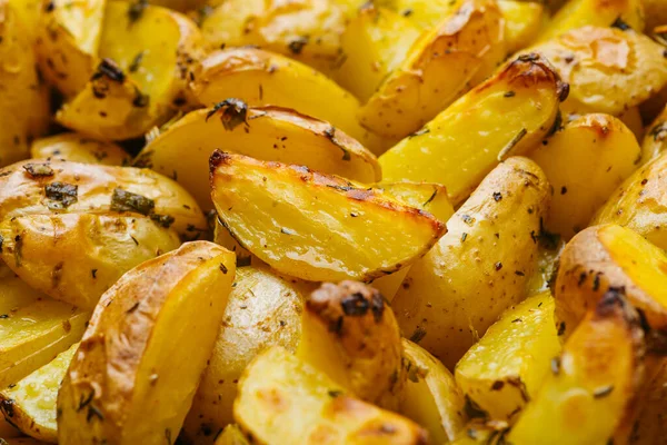 Roasted potatoes in a rustic backgarund. Slices of rustic fried potatoes with spices.