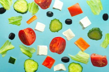 Salata için gerekli malzemeler. Yunan salatası tarifi. Taze sebzeler (domatesler, salatalıklar, zeytinler) ve peynir en az mavi boş arkaplanda..