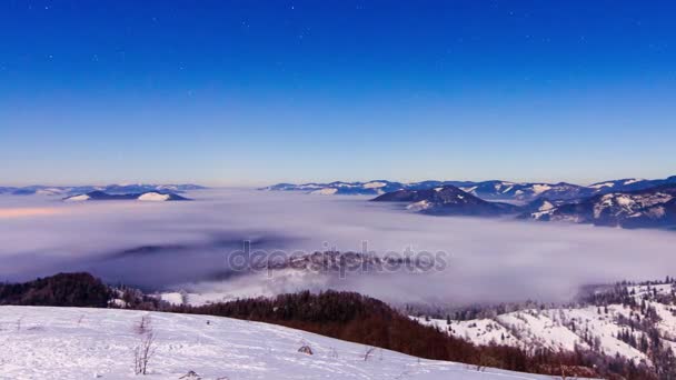 Mist beweegt zich in de winter over de berg met een stervormige hemel — Stockvideo