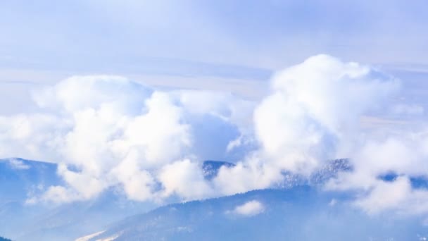 Paisaje de invierno. Niebla moviéndose sobre la montaña en invierno con un cielo azul — Vídeo de stock