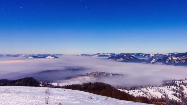 Brouillard se déplaçant sur la montagne en hiver avec un ciel étoilé — Video