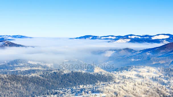 Paisaje de invierno. Niebla moviéndose sobre la montaña en invierno con un cielo azul — Vídeos de Stock