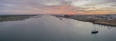 Olhao Tersane, waterfront Ria Formosa doğal parkına ve Armona Island günbatımı hava panoramik deniz manzarası görünümünü.