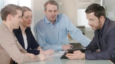 Yeni planları bir tablet üzerinde tartışırken iş adamları