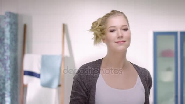 Blonde attraktive Frau öffnet ihren Zopf mit einem Wunschlächeln vor dem Spiegel — Stockvideo