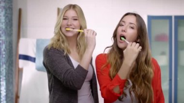Birlikte diş fırçalama iki genç kadın kamera infront