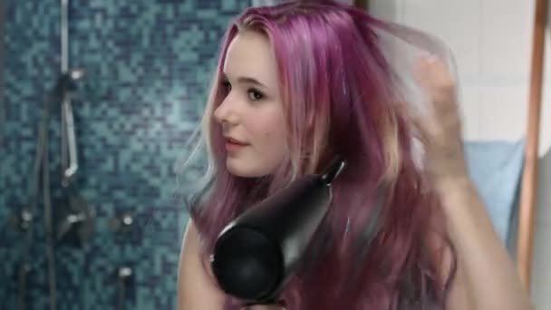 Девушка с розовыми волосами высушивает волосы — стоковое видео