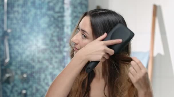 Ελκυστική νεαρή γυναίκα ΠΙΝΕΛΑ τα μακριά καστανά μαλλιά — Αρχείο Βίντεο