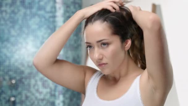 Jovem mulher atraente brinca com seu longo cabelo castanho — Vídeo de Stock