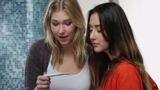 Friends celebrating pregnancy test results in a modern bathroom — Stock Video