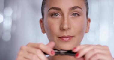 Çekici kadın maskara açar ve kameraya winks