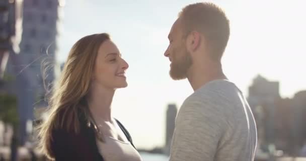 Ungt par står inför varandra och hon smeker hans ansikte — Stockvideo