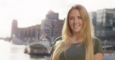 Modern Limanı önünde kameraya gülümseyen çekici sarışın kadın