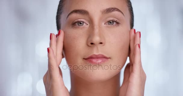 Aantrekkelijke vrouw die haar huid masseren terwijl ze op de camera naar op zoek is — Stockvideo