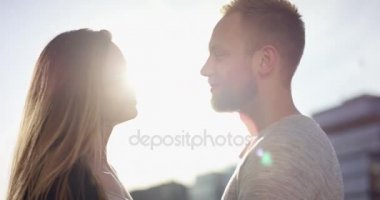 Genç çift birbirlerine güzel arkadan aydınlatmalı yazında bir gün batımı içinde karşı karşıya