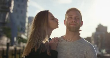 Serin genç kadın sevgilisi yanak üzerinde yumuşak bir öpücük veriyor