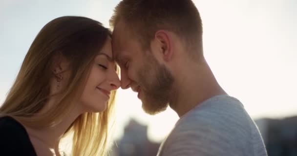 Мила пара кохання стоїть носом до носа на заході сонця — стокове відео