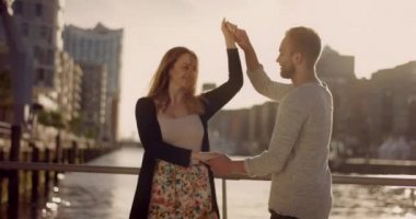 Genç aşk günbatımı liman kenti önünde dans çift