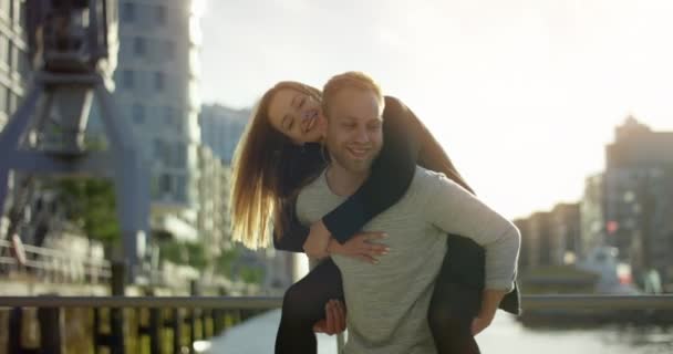 Linda chica consiguiendo un cerdito espalda paseo de su novio — Vídeos de Stock