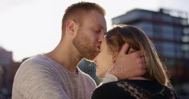 Kız arkadaşın alnına yumuşak bir öpücük vererek çekici genç adam