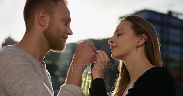 Atractiva pareja bebiendo alegremente de una botella con una pajita — Vídeo de stock