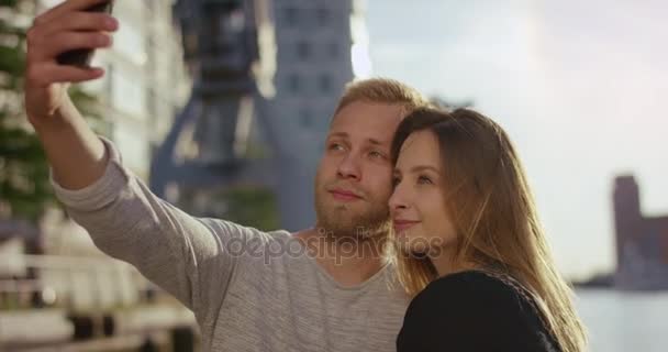 Attractive young tourist couple taking selfie in front of docks — Stock Video