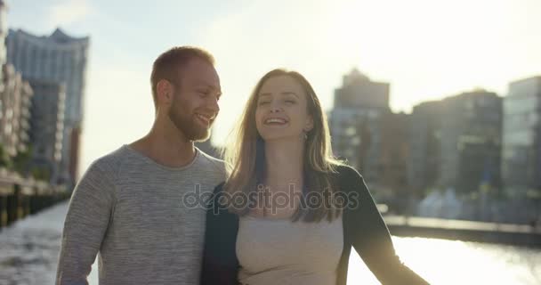 Молодая пара, стоящая рядом и улыбающаяся — стоковое видео