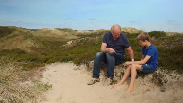 Grandpa on hill telling grandchild about plants — Stock Video