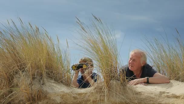 Grandfather and grandchild hiding and looking through binoculars — Stock Video