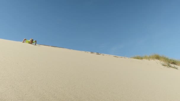 Дитина ковзає вниз піщана дюна — стокове відео